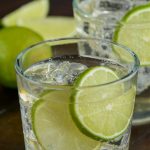 glass of the perfect gin and tonic with two lime slices