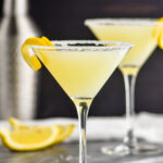 two glasses of lemon drop martini with sugared rims and a lemon twist