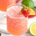 glass of virgin strawberry daiquiri with fresh strawberry and lime garnish