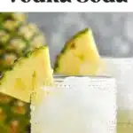Pinterest graphic for Pina Colada Vodka Soda. Text says "the best pina colada vodka soda shakedrinkrepeat.com" Image shows two glasses of Pina Colada Vodka Soda with ice and garnished with pineapple wedge. Fresh pineapple sitting in background.